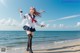 A woman in a school uniform standing on a beach.