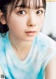 A close up of a woman's face with a blue shirt.