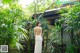 A woman in a white dress standing in a garden.