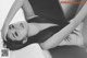 A woman laying on top of a bed with her hands behind her head.